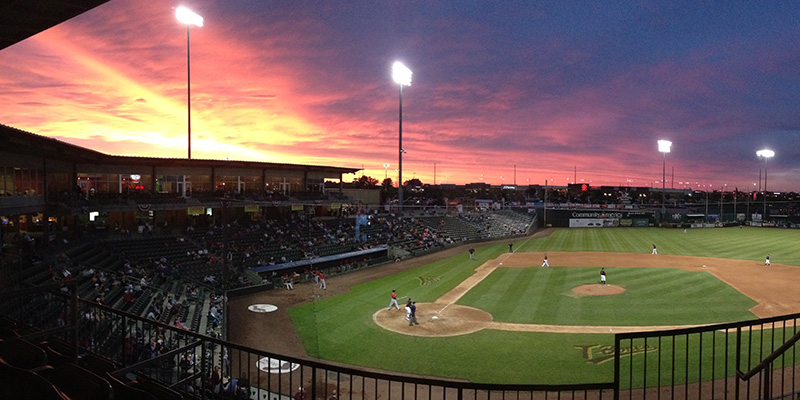 Legends Field baseball diamond beneath a colorful sunset