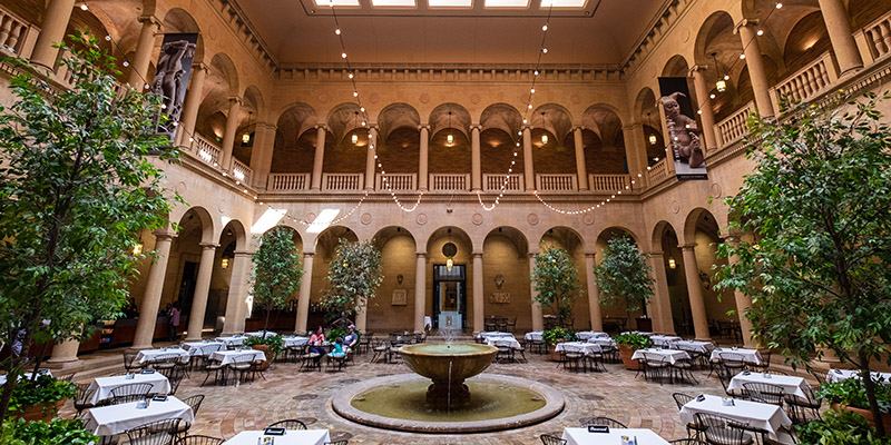 Indoor courtyard at the Nelson-Atkins Museum of Art, filled with white linen-covered tables