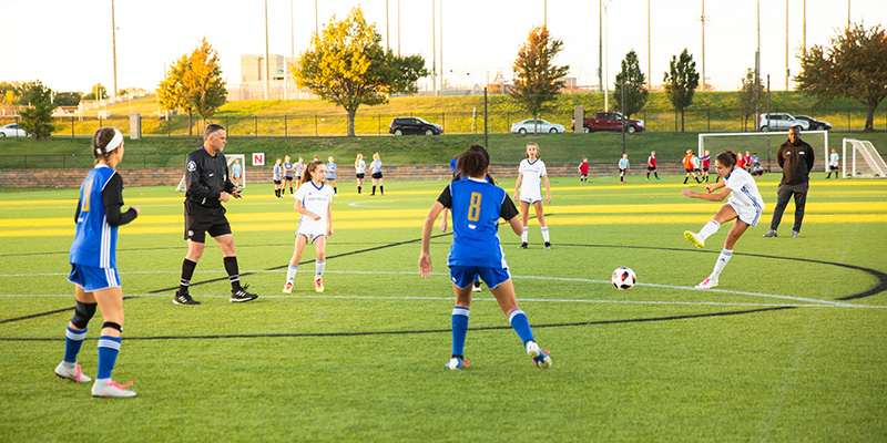 Youth soccer players on the field at sunset