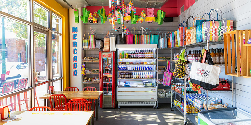 Colorful shelves full of goods at Taco Naco KC with sign that reads "Mercado"