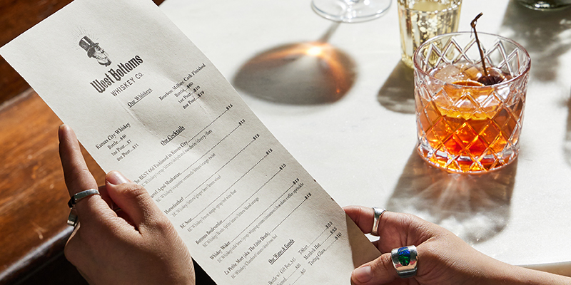 Cocktail menu and drink at West Bottoms Whiskey Co.