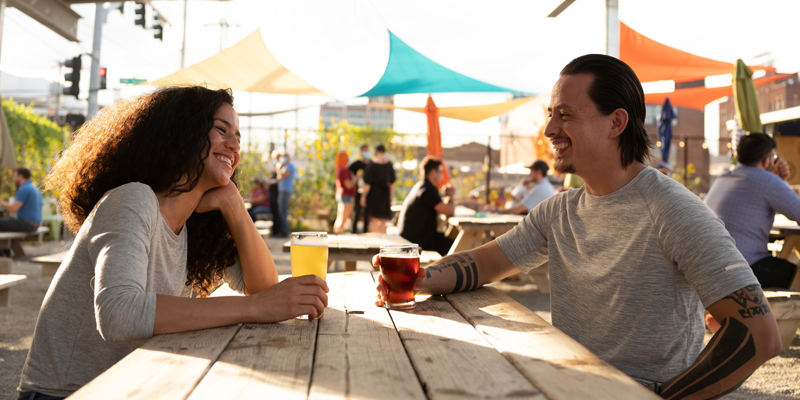 A young couple sitting on the patio, enjoying drinks at Brewery Imperial in the East Crossroads in Kansas City